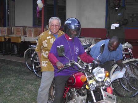 Bishop Mwita on a test ride of  donated motorcyle