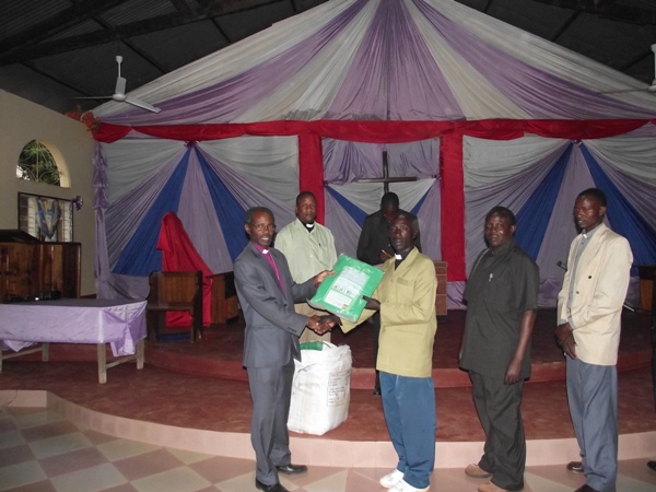 Bishop Mwita giving donated bed nets to the pastors on August 25