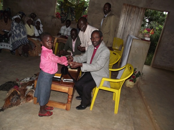 A little boy donating money during a fundraising for music instruments at Kitagasembe parish church