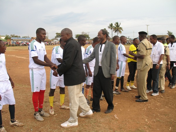 Guest of Honour, Mr Kabohola (in black jacket), Bishop Mwita & Police Commander greeting the soccer players before the inaugural match.