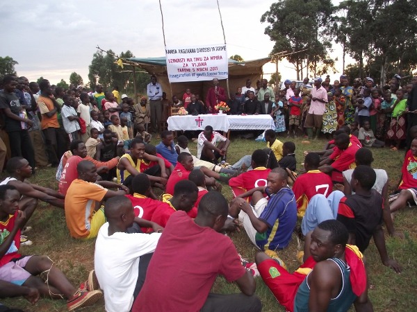 Players and the crowd listening to Bishop Mwita at Kenyamanyori Village